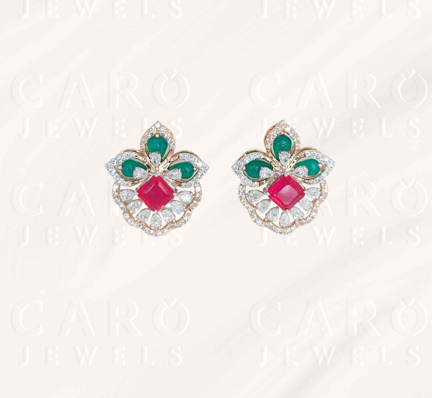 Pair of earrings with green and red gemstones .