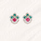 Pair of earrings with green and red gemstones .